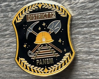 Pin esmaltado distópico del Distrito 12
