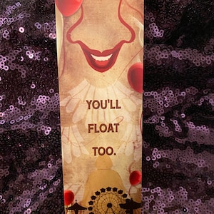 Könnte beinhalten: Ein Lesezeichen mit einem gruseligen Clown mit einem roten Ballon und dem Text "You'll Float Too."