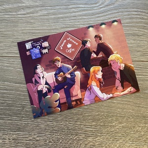 Peut inclure: Une impression rectangulaire représentant une scène de café avec plusieurs personnages. L'enseigne indique "Java Jones Coffee". Un personnage joue de la guitare. La palette de couleurs comprend des bruns, des rouges et des bleus.