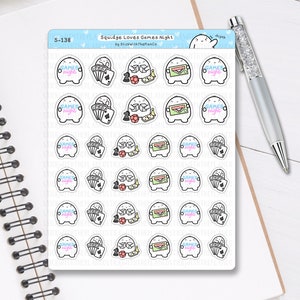 May include: A sheet of stickers with a cartoon character and game-themed designs. The stickers feature playing cards, dice, and the text "Games Night" in a colourful font. The stickers are on a white background.