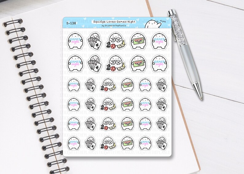 May include: A sheet of stickers with a cartoon character and game-themed designs. The stickers feature playing cards, dice, and the text "Games Night" in a colourful font. The stickers are on a white background.