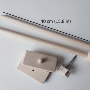 May include: A set of wooden dowels for hanging macrame or other crafts. The dowels are 40 cm (15.8 in) long and come with a hook, a knob, and a wooden base.