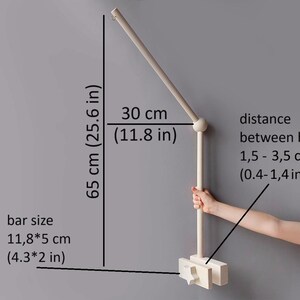 May include: White wooden mobile arm with a 30-inch (76 cm) long arm and a 11.8-inch (30 cm) vertical bar. The arm is adjustable and can be moved to different positions. The distance between the bars can be adjusted from 0.4 to 1.4 inches (1.5 to 3.5 cm).