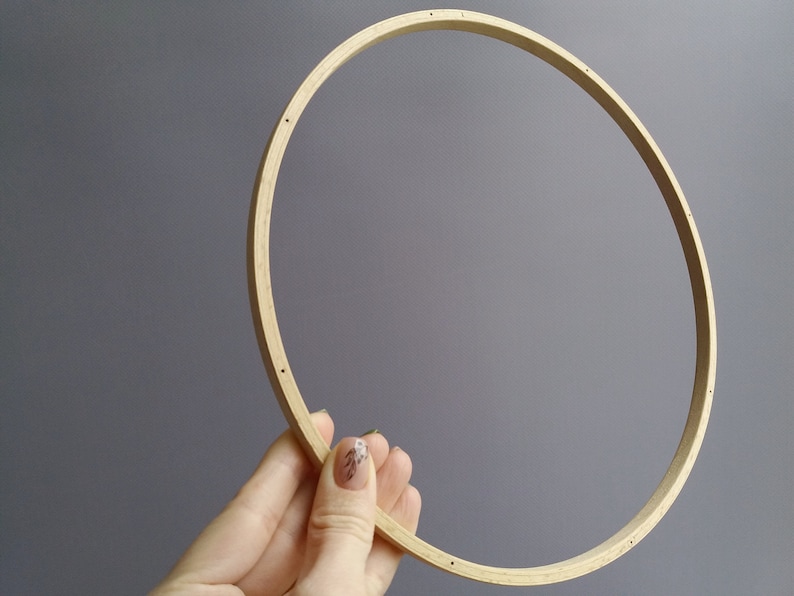 Op de afbeelding: Een ronde houten borduurring met een natuurlijke afwerking. De ring heeft een diameter van ongeveer 25 cm.