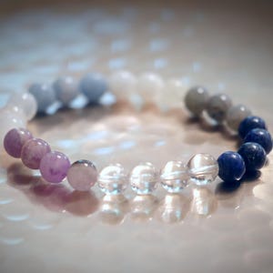 May include: A beaded bracelet with amethyst, clear quartz, moonstone, and lapis lazuli beads.