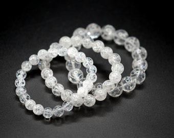May include: Three clear quartz crystal bracelets with a textured surface.