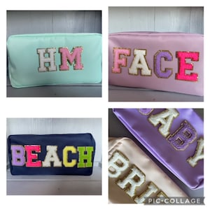 May include: Four different cosmetic bags with colourful letters spelling out "HM", "FACE", "BABY", and "BEACH". The letters are made of fluffy fabric with gold glitter accents.