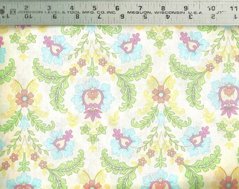 May include: A white fabric with a repeating pattern of light blue, pink, and yellow flowers with green leaves. The flowers have a paisley-like design.