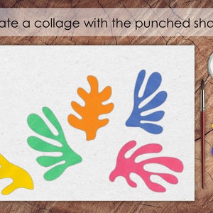 May include: A white sheet of paper with five colorful paper shapes cut out in the shape of leaves. The shapes are orange, green, blue, pink, and yellow. The paper is on a wooden surface.