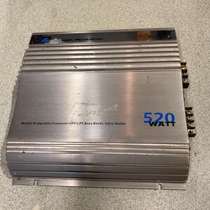 May include: A silver Power Acoustik PS2-520 car audio amplifier with a brushed metal finish. The unit features blue text reading 520 WATT and black text listing features including Mosfet, Bridgeable, Crossover, HPF/LPF, Bass Boost, and 2ohm Stable.