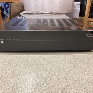 May include: A black Episode EA-AMP-8D-70A multi-channel amplifier featuring a power button with an indicator light on the left side, a series of eight numbered status lights, and a ventilated top panel with multiple rectangular slots.