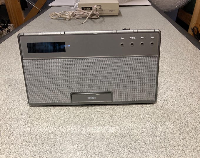 RCA Alarm Clock Radio/ iPod. Model No. RC65i-A. Powers On...No Further Testing.