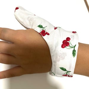 thumb cover, anti-sucking glove, help them stop sucking their thumb, left and right handed, adjustable closure, cherry pattern