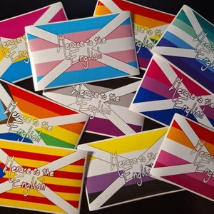 Puede incluir: Una colección de pegatinas con un diseño de bandera escocesa y el texto "Menace to the English" en una variedad de colores, incluyendo las banderas del orgullo arcoíris, transgénero y bisexual.