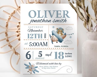 May include: A blue and brown baby announcement card with a teddy bear in a plane. The card says "Oliver jonathan smith" and includes the baby's birth date, time, weight, and length. The text says "Saturday November 12th 2022 at 5:00AM Tampa, Florida 6 pounds 5 ounces and 18 inches long. Welcomed with love by Mom Ashley, Dad Robert & Big sister Emily"