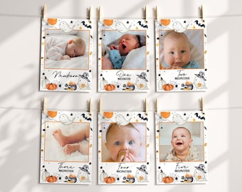 May include: Six white photo frames with black borders and a Halloween theme. Each frame has a ghost, bats, and stars. The frames are hung on a string with clothespins. The frames are labeled with the ages "Newborn", "One Month", "Two Months", "Three Months", "Four Months", and "Five Months".