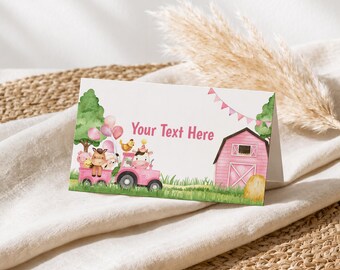 May include: A rectangular folded card featuring a watercolor illustration of a pink tractor pulling a trailer with farm animals, a pink barn, green trees, and pink balloons. The text Your Text Here is printed in pink in the center.
