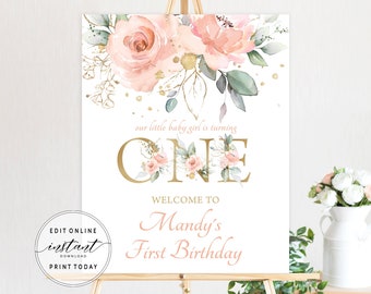 May include: A white printable sign with gold and pink floral accents. The text reads "our little baby girl is turning ONE" and "WELCOME TO Mandy's First Birthday".