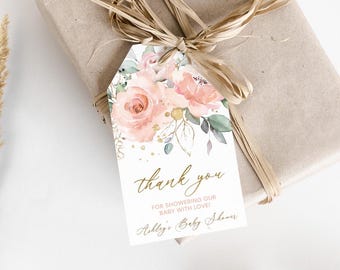 May include: A white thank you tag with gold lettering and a watercolor floral design featuring pink roses and green leaves. The text reads "Thank you for showering our baby with love! Ashley's Baby Shower".