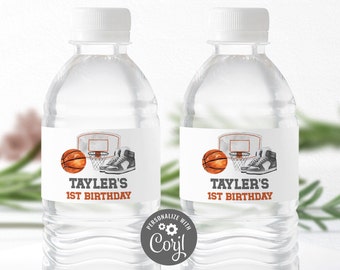 May include: Two clear plastic water bottles with white labels. The labels feature a basketball, basketball hoop, and trainers. The text on the labels reads "Tayler's 1st Birthday".
