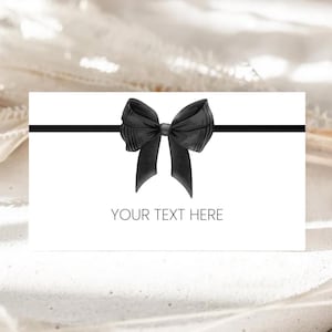 May include: A white card with a black ribbon and bow. The text "YOUR TEXT HERE" is printed on the card.