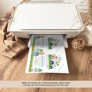 May include: A white printer printing invitations. The invitations feature a blue truck with animal illustrations and the text "Oliver's 1st Birthday". The invitations also include the text "Calling All Party Animals!"