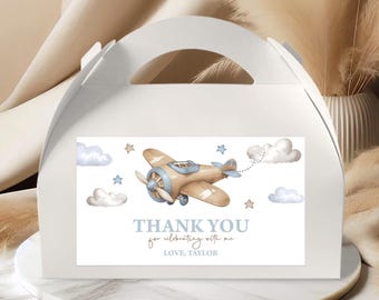 May include: White favor box with a blue and brown airplane illustration and the text "Thank you for celebrating with me Love, Taylor".