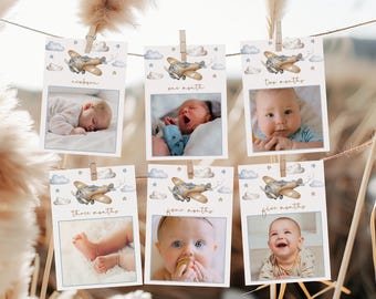 May include: Six photo cards with a blue and white airplane design. Each card has a different age milestone: newborn, one month, two months, three months, four months, and five months. Each card has a photo of a baby.
