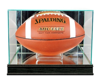 May include: A brown and white football with the text "SPALDING ADVANCE" is displayed inside a clear glass display case with a black base. The football is resting on a clear stand.