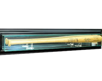 May include: A wooden baseball bat displayed in a black framed glass case. The bat is light brown with printed text and a signature. The case is rectangular and mounted on a white background.