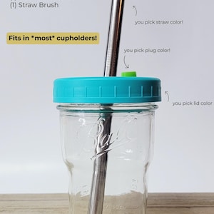 May include: A clear 16 oz Ball nesting mason jar with a teal lid, stainless steel straw, and green plug. The text reads "WHAT YOU'LL GET:" and lists the included items. The text also says "Fits in *most* cupholders!"