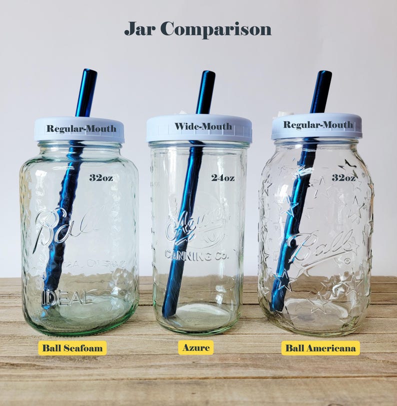 K&ouml;nnte beinhalten: Drei Gl&auml;ser mit wei&szlig;en Deckeln und blauen Metallstrohhalmen. Das linke Glas ist ein 32oz Ball Seafoam, das mittlere ein 24oz Wide-Mouth Azure und das rechte ein 32oz Ball Americana mit Sternenmuster. Jedes Glas hat Textetiketten f&uuml;r Gr&ouml;&szlig;e und Typ.