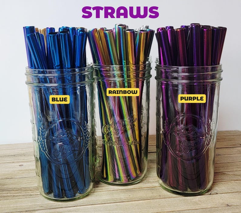 K&ouml;nnte beinhalten: Drei durchsichtige Gl&auml;ser gef&uuml;llt mit Metallstrohhalmen. Das linke Glas enth&auml;lt blaue Strohhalme mit der Aufschrift 'BLUE', das mittlere Glas regenbogenfarbene Strohhalme mit 'RAINBOW' und das rechte Glas violette Strohhalme mit 'PURPLE'. Oben steht der Text 'STRAWS'.