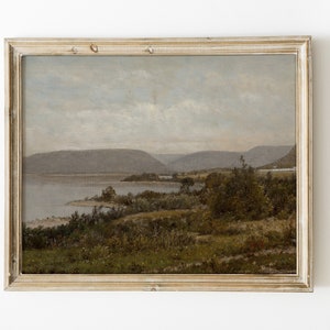 May include: A framed landscape painting depicting a lake with mountains in the background. The painting is done in muted tones of blue, green, and brown.