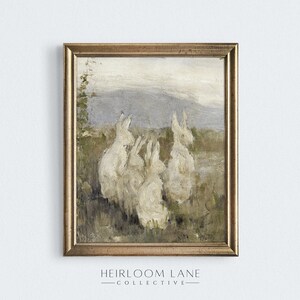 May include: A vintage painting of four white rabbits sitting in a field with a mountain range in the background. The painting is framed in a gold frame.