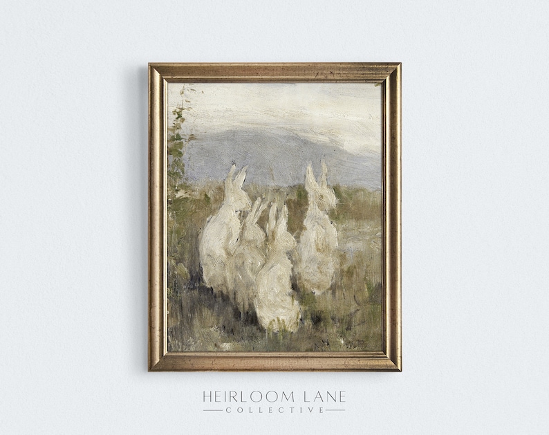 May include: A vintage painting of four white rabbits sitting in a field with a mountain range in the background. The painting is framed in a gold frame.
