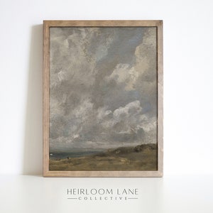 May include: A framed painting of a landscape with a cloudy sky. The sky is a light blue with white clouds. The landscape is a brown field with a few trees in the distance.
