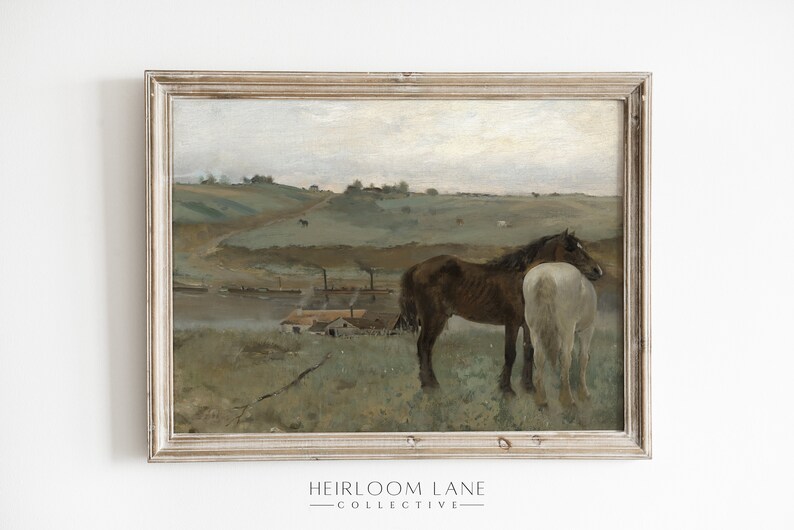 May include: A framed oil painting depicting a rural landscape with two horses standing in a field. The horses are brown and white, and they are standing close together. The background of the painting shows a river, a small village, and rolling hills.