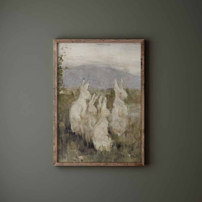 May include: A framed painting of a group of white rabbits in a field. The rabbits are gathered together, and the painting has a soft, muted color palette.