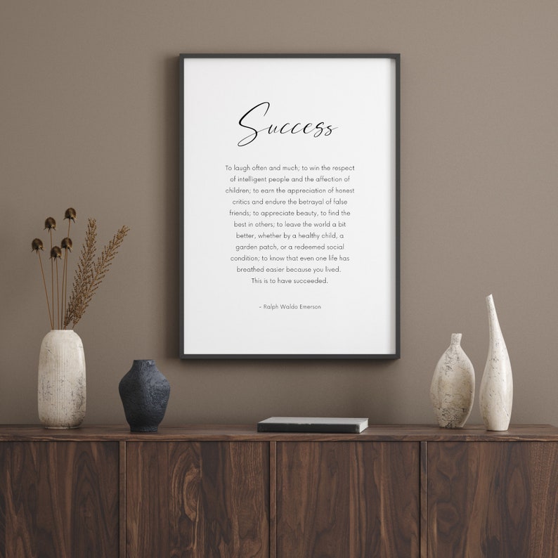 Puede incluir: Impresi&oacute;n enmarcada con la palabra &laquo;&nbsp;Success&nbsp;&raquo; en escritura elegante. Debajo, una cita de Ralph Waldo Emerson se muestra en una fuente limpia y moderna. La impresi&oacute;n se encuentra sobre un fondo neutro, con jarrones decorativos y un libro.