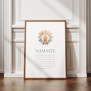 May include: A white framed print with a gold and blue mandala design and the word "Namaste" in a gold font. The text below the mandala reads "My soul honours your soul. I honour the place in you where the entire universe resides. I honour the light, love, truth, beauty & peace within you because it is also within me. In sharing these things, we are united. We are the same, we are one."