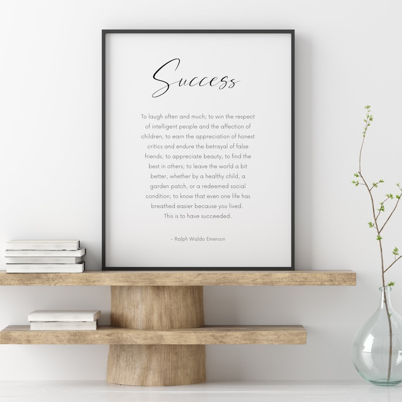 Puede incluir: Impresi&oacute;n enmarcada con la palabra "Success" en escritura cursiva. La impresi&oacute;n presenta una cita de Ralph Waldo Emerson. Se encuentra sobre una estanter&iacute;a de madera con libros y un jarr&oacute;n.