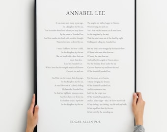 May include: Black and white print of the poem "Annabel Lee" by Edgar Allan Poe. The poem is framed in a black frame and is hanging on a wall.