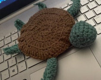 May include: A crocheted turtle toy with a brown shell and teal green limbs and head.