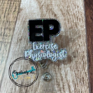 Pode incluir: Um porta-crach&aacute; de glitter prateado com um texto preto e branco "EP" para "Exercise Physiologist". O porta-crach&aacute; tem um carretel retr&aacute;til de pl&aacute;stico transparente.