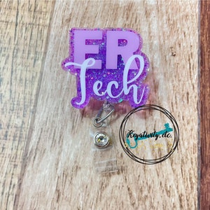 Op de afbeelding: Paarse glitter badgehouder met een witte inscriptie "ER Tech". De badgehouder heeft een transparante plastic clip en een kleine, heldere strasssteen.