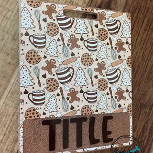 May include: A rectangular badge holder with a brown and white pattern of gingerbread men, mugs, cookies, and Christmas trees. The bottom section has the word "TITLE" in large, black letters on a glittery brown background.