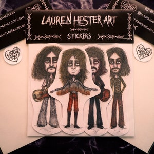May include: Four black and white illustrated stickers of musicians with long hair. The stickers are on a white background with black text that reads "Lauren Hester Art Stickers".
