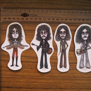 May include: Four illustrated figures of musicians with long hair, each holding a different musical instrument. The figures are drawn in black and white with some color accents. The figures are on a white background.