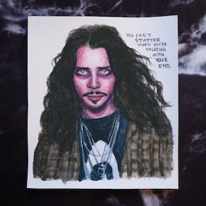 Könnte beinhalten: Ein Aquarellbild eines Mannes mit langen dunklen Haaren und einem karierten Hemd. Er blickt dem Betrachter mit einem ernsten Ausdruck direkt an. Der Text "You can't stutter when you're talking with your eyes." ist in der oberen rechten Ecke des Bildes geschrieben.